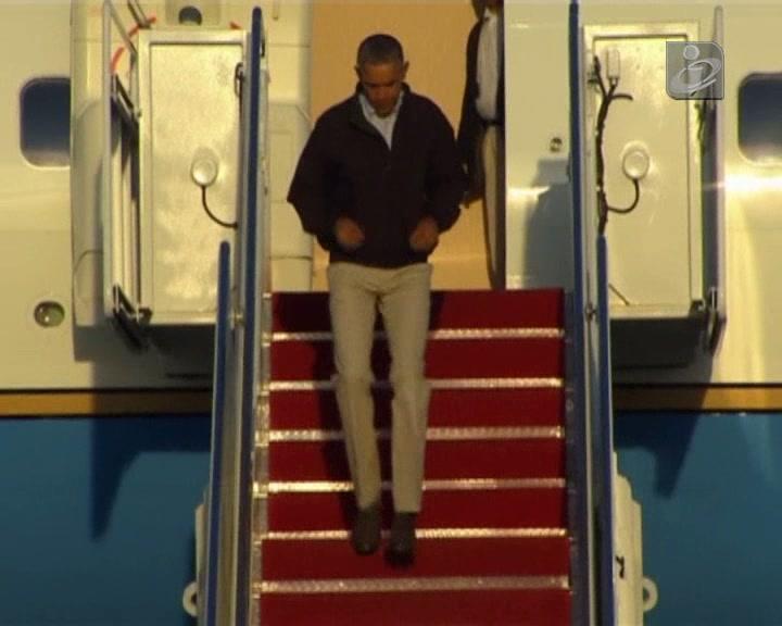 Obama escorrega à saída de avião