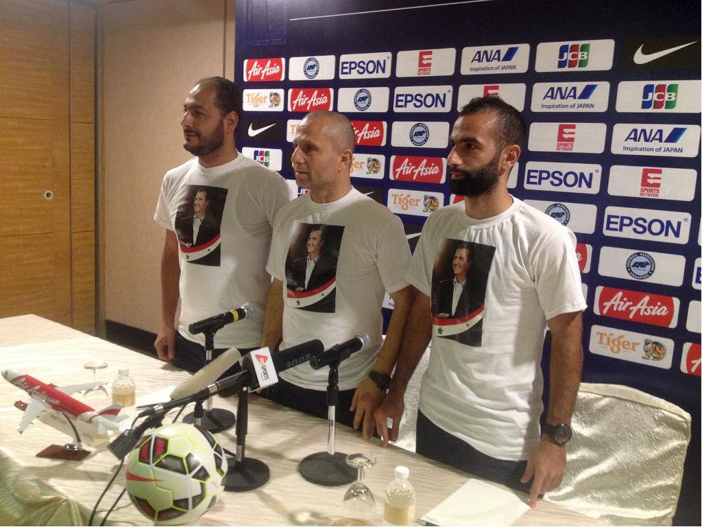 Selecionador e jogador da Síria com t-shirt de apoio ao presidente Bashar al-Assad