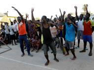 Migrantes jogam futebol em centro de detenção em Tripoli ( Reuters )