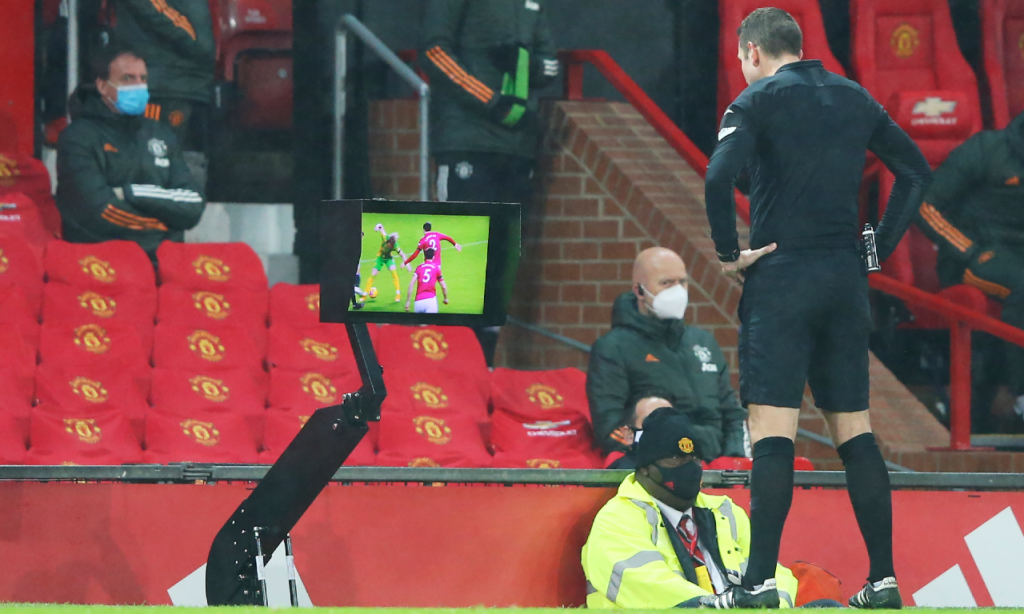 Árbitro analisa possível penálti no vídeo-árbitro, no Manchester United-West Bromwich. Falta de Bruno Fernandes sobre Gallagher foi revertida  (AP)