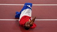 Uma das figuras desta 2.ª feira: a holandesa Sifan Hassan festeja no chão, enrolada na bandeira, o ouro nos 5 mil metros, conseguido num dia em que venceu a série das eliminatórias dos 1.500 metros após ter sofrido uma queda (AP)