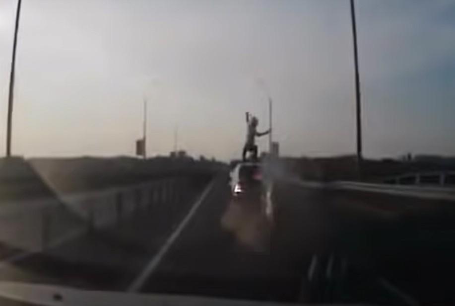 Motociclista aterra em cima de carro (captura YouTube)