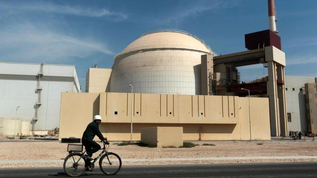 Trabalhador anda de bicicleta em frente ao edifício da central de Bushehr