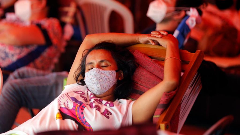 Mulher dorme em sala de espera de hospital no Paraguai (Jorge Saenz/AP)