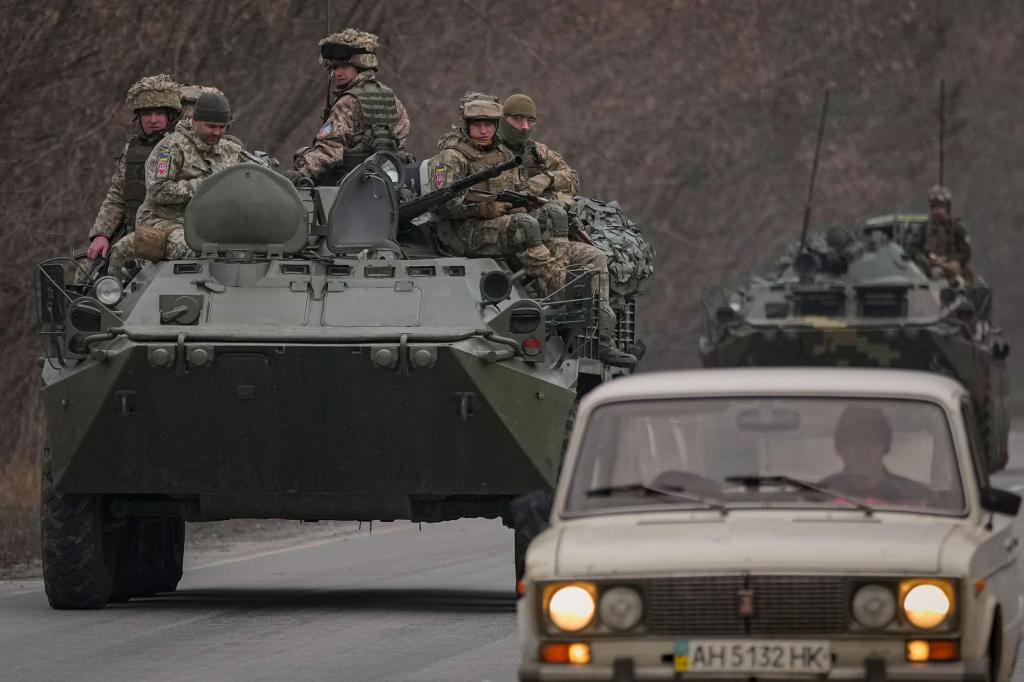 Militares ucranianos sentados no cimo de veículos blindados, numa estrada da região de Donetsk, no leste da Ucrânia, na quinta-feira. Vadim Ghirda/AP