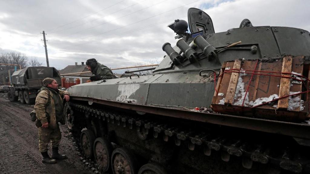 Soldados fardados sem insígnias são vistos ao lado de um carro de combate com o símbolo “Z” pintado de lado, na vila de Bugas, controlada pelos separatistas, na região de Donetsk, na Ucrânia.