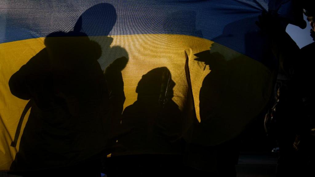 Manifestantes com a bandeira da Ucrânia. (AP Photo/Andreea Alexandru)