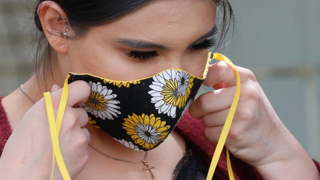 Mulher com máscara de proteção facial. (AP Photo/Rick Bowmer)