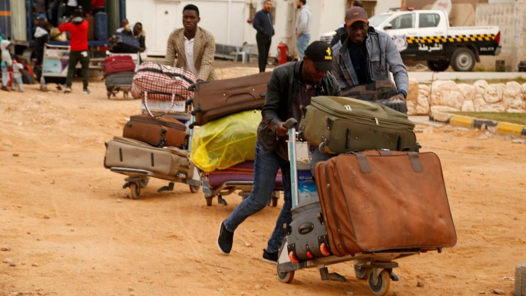 Migrantes esperam para embarcar num voo para o Níger, em Misrata, na Líbia, a 21 de abril 2022. As autoridades da Líbia, em cooperação com a Organização Internacional para as Migrações (OIM), repatriaram 160 migrantes de Níger, retomando voos voluntários para deportar migrantes do país. (Foto AP/Yousef Murad)