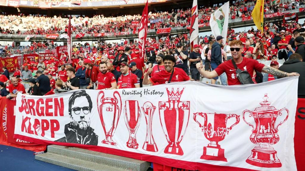 Adeptos do Liverpool na final da Liga dos Campeões, exibindo uma faixa com Jurgen Klopp e com os títulos