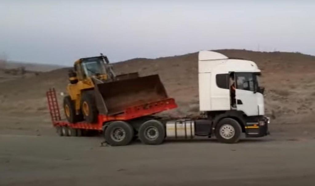 Camião e retroescavadora são puxados por Toyota Land Cruiser (captura YouTube)