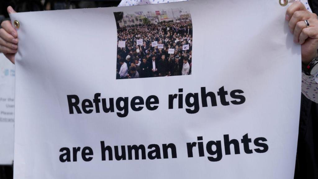 "Direitos dos refugiados são direitos humanos", lê-se num cartaz de protesto contra o acordo de asilo do Reino Unido com o Ruanda (AP Photo/Frank Augstein)