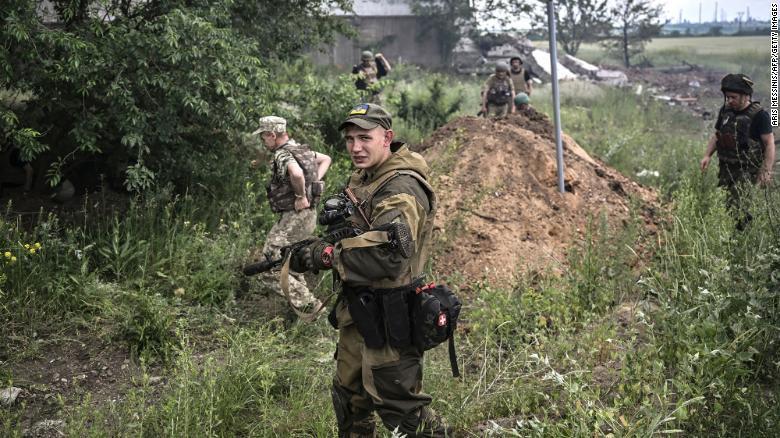 Um militar ucraniano observa o resultado de um ataque a um armazém perto de Lysychansk a 17 de junho de 2022