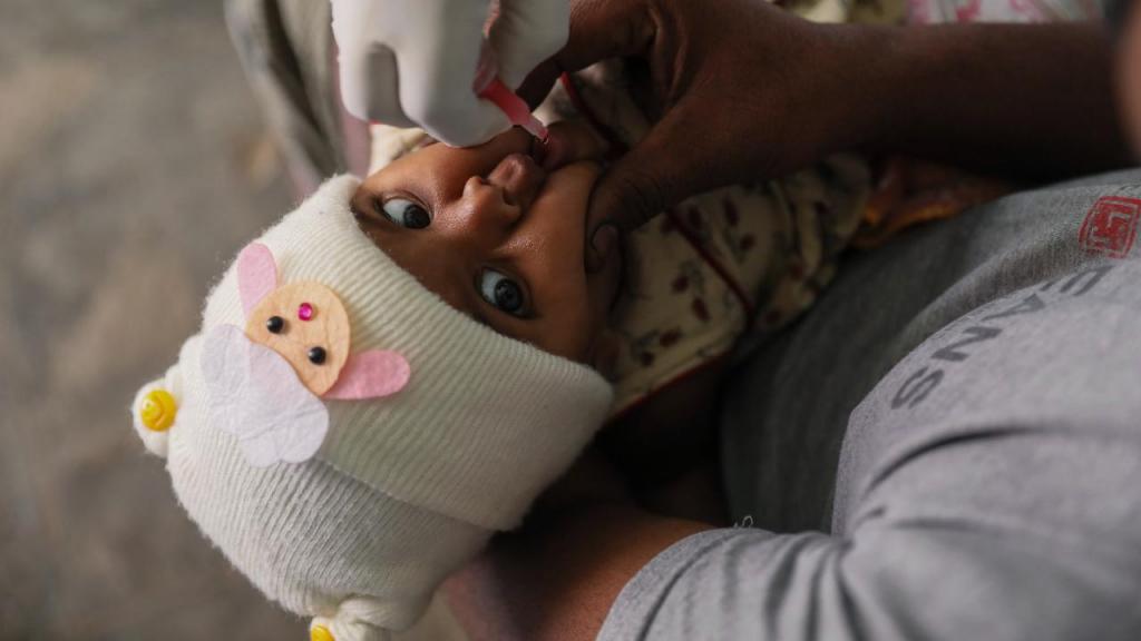 Um voluntário médico administra uma dose de vacina contra a poliomielite a uma criança em Hyderabad, na Índia, em fevereiro de 2022. (AP Photo/Mahesh Kumar A.)