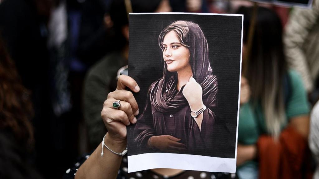 Manifestante segura um retrato de Mahsa Amini (Photo by KENZO TRIBOUILLARD/AFP via Getty Images)