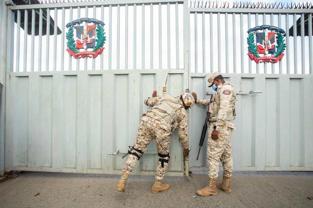 Membros do Corpo Especializado de Segurança de Fronteiras (Cesfront) abrem o portão de entrada na ponte fronteiriça de Dajabon e Ouanaminthe, em Dajabon, República Dominicana, no domingo, a 14 de agosto de 2022. Foto: Tatiana Fernandez Geara/Bloomberg/Getty Images/FILE