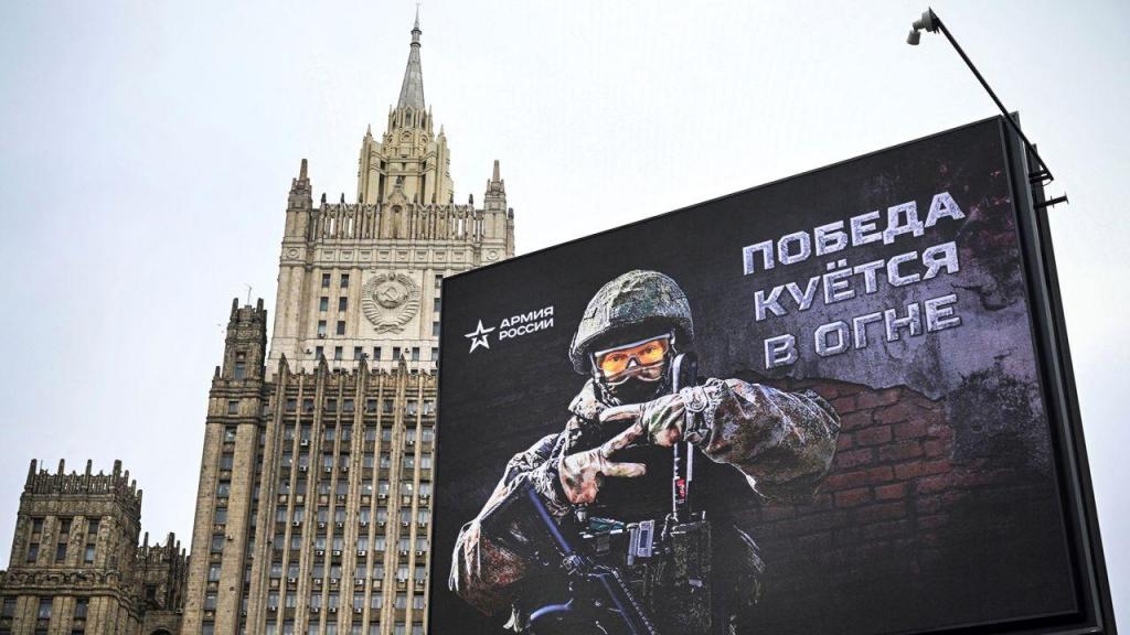 O edifício do Ministério dos Negócios Estrangeiros russo é visto atrás de um painel publicitário que mostra a letra “Z”, uma insígnia tática das tropas russas na Ucrânia, e onde se pode ler “A vitória está a ser forjada em fogo”, no centro de Moscovo, a 13 de outubro de 2022. Créditos: Alexander Nemenov/AFP/Getty Images