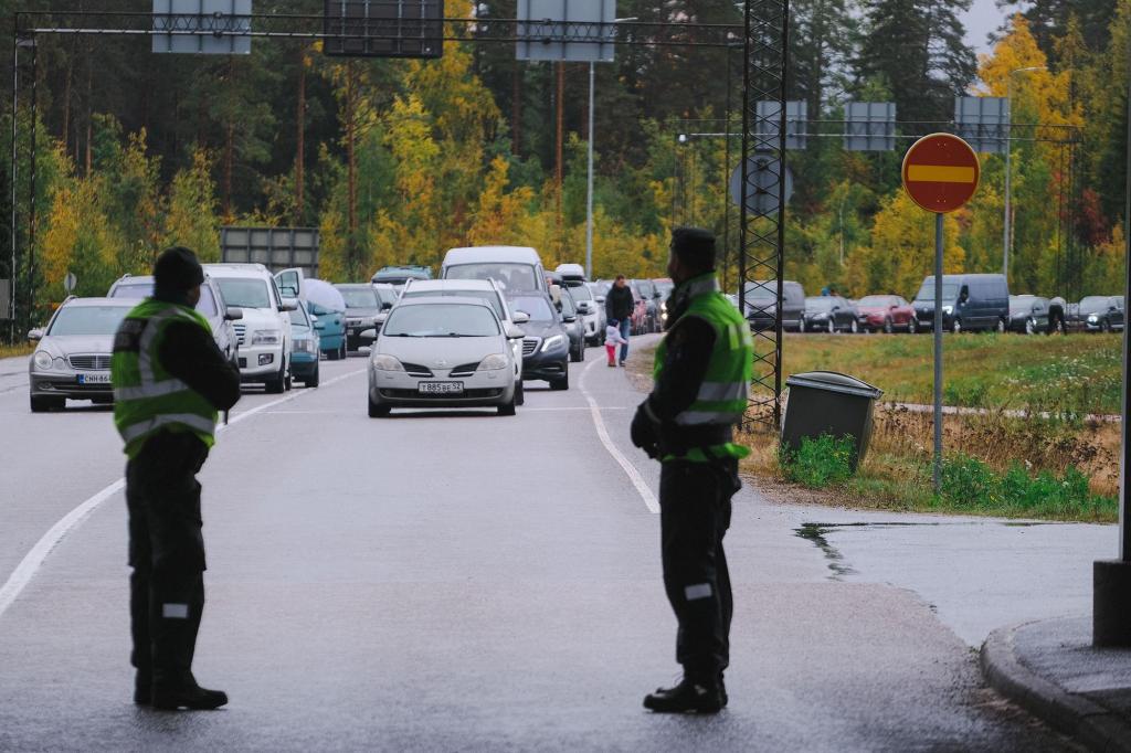 Guardas de fronteira finlandeses observam a fila de carros na fronteira de Vaalima, entre a Finlândia e a Rússia, a 30 de setembro de 2022 (Foto: Alessandro Rampazzo/AFP/Getty Images)