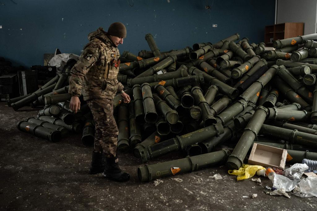 Um soldado ucraniano junto a uma pilha de restos de munições de morteiros lançados pela Rússia sobre Bakhmut. 15 fevereiro 2023. Foto: Yasuyoshi Chiba/AFP via Getty Images