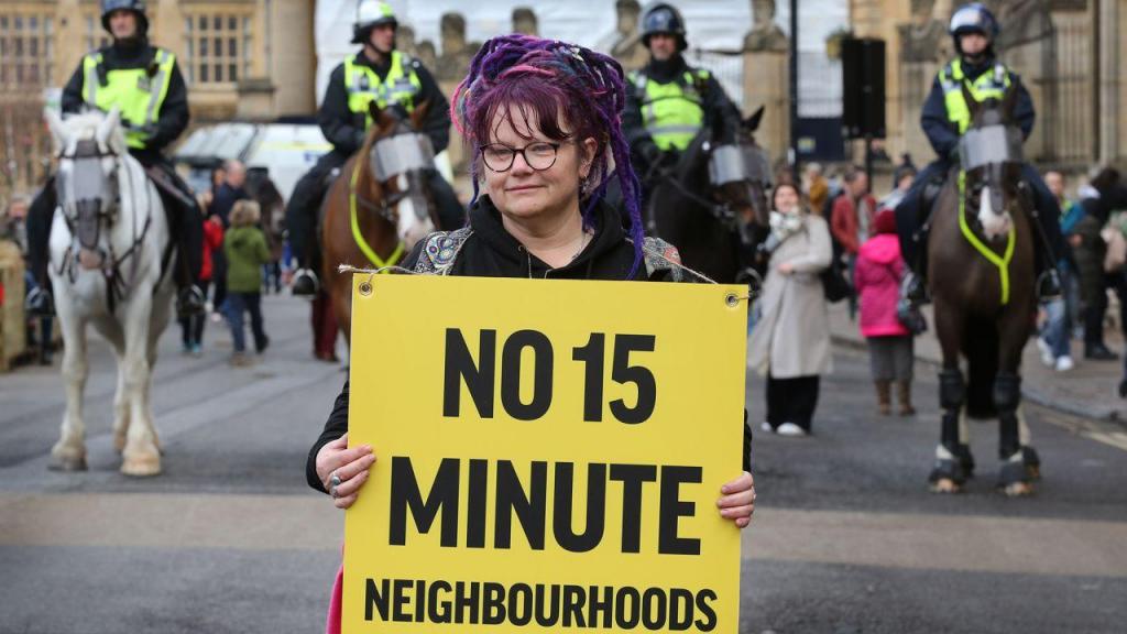 Uma mulher segura um cartaz num protesto contra "cidades de 15 minutos" em Oxford, Inglaterra, a 18 de fevereiro de 2023. Martin Pope/Getty Images