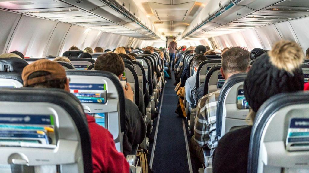 Passageiros sentados dentro de um avião. Daniel Avram/Adobe Stock