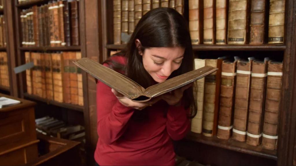 Cecilia Bembibre cheira um livro histórico da biblioteca da Catedral de São Paulo, em Londres. FMartin