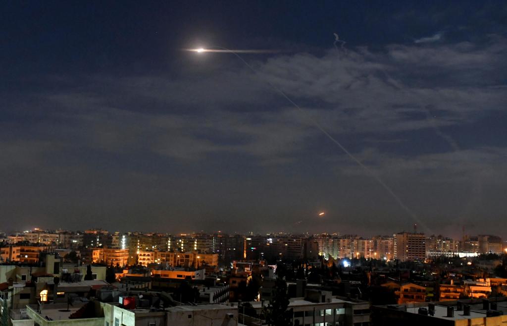 Fotografia disponibilizada pela agência de notícias síria SANA, que mostra mísseis a voar sobre o céu perto do aeroporto internacional, na Síria