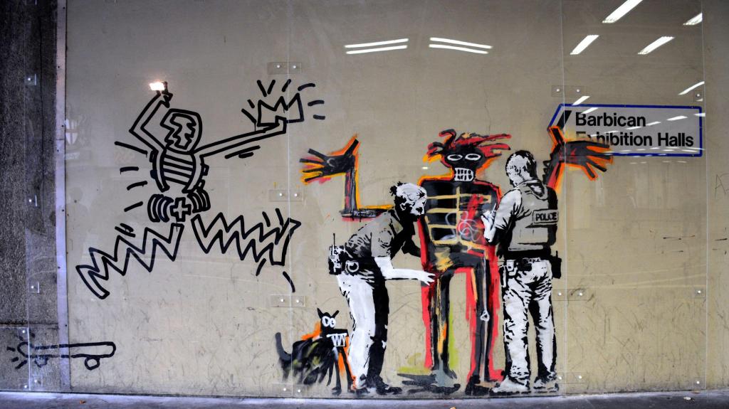 Graffiti de Bansky no Barbican Center, em Londres, representa o artista norte-americano Basquiat a ser revistado pela polícia. Setembro 2017. Foto:  Robert Alexander/Getty Images