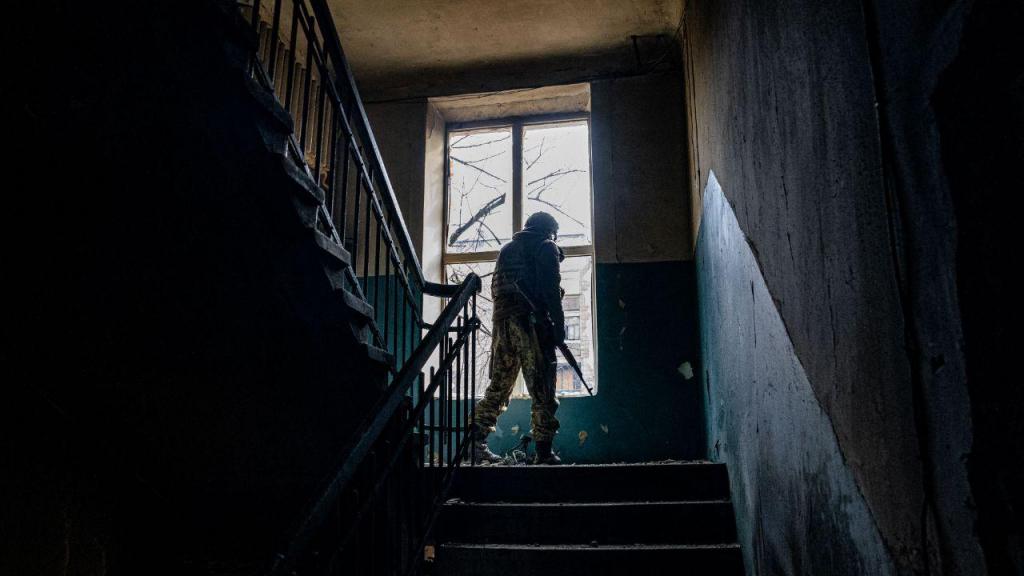 Soldado ucraniano observa posições inimigas a partir do interior de um edifício, na cidade de Bakhmut (Getty Images)