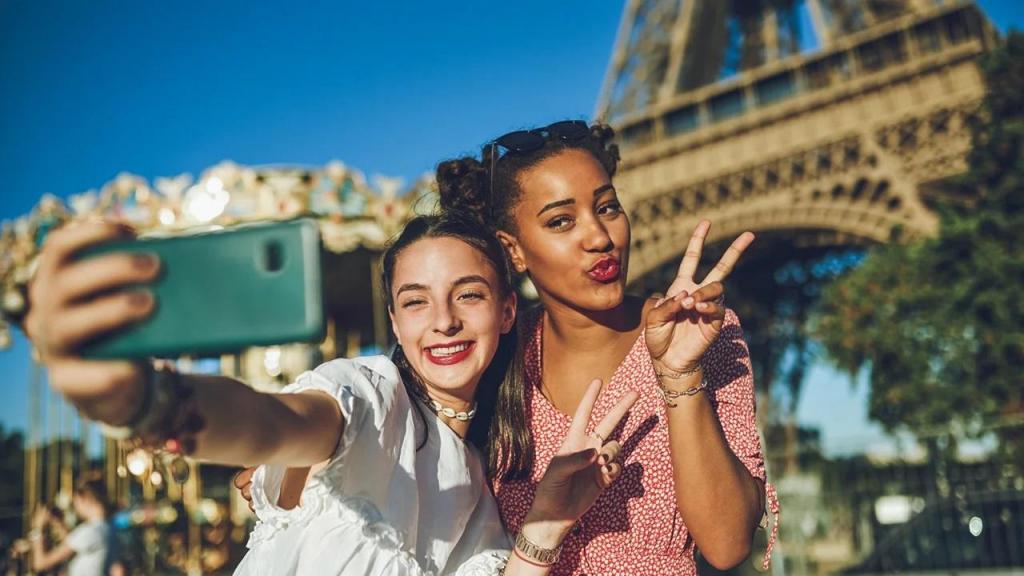 Turistas fotografam-se em selfies de telemóvel smartphione numa viagem de turismo em Paris para as redes sociais como o Instagram Foto Charday Penn _ E+ _ Getty Images