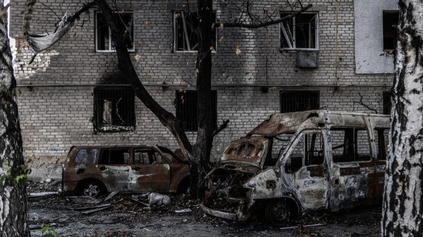 Carros queimados em frente a um prédio danificado na cidade de Orikhiv, na linha da frente, no sul da Ucrânia. Oliver Weiken/picture alliance/Getty Images