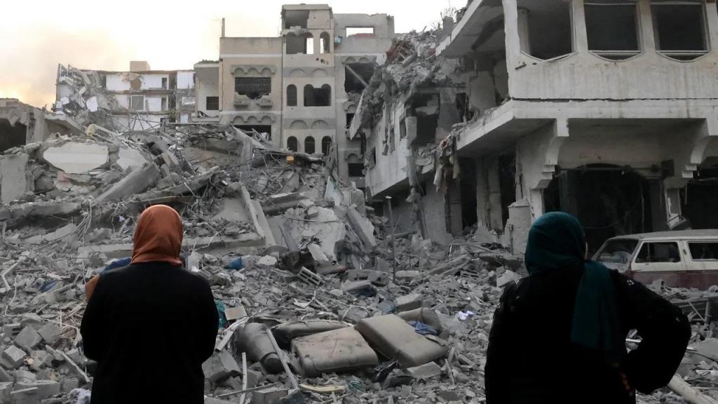 Duas mulheres palestinianas observam a destruição maciça após os ataques aéreos israelitas no bairro de al-Rimal, na cidade de Gaza, a 10 de outubro. Mahmud Hams_AFP_Getty Images