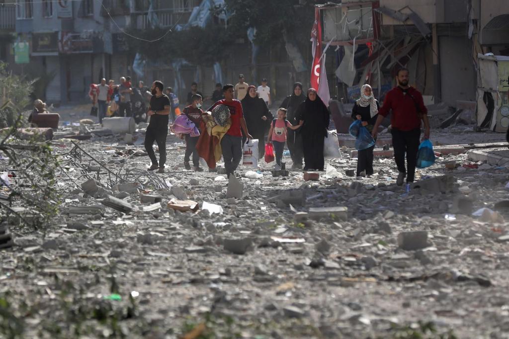 Palestinianos deixam as casas na cidade de Gaza após bombardeamentos israelitas (Foto: Abed Khaled/AP)